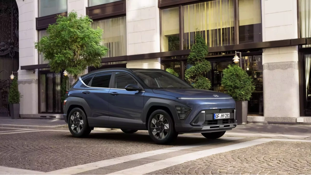 Hyundai KONA Hybrid de profil, à l’arrêt, devant un bâtiment moderne.